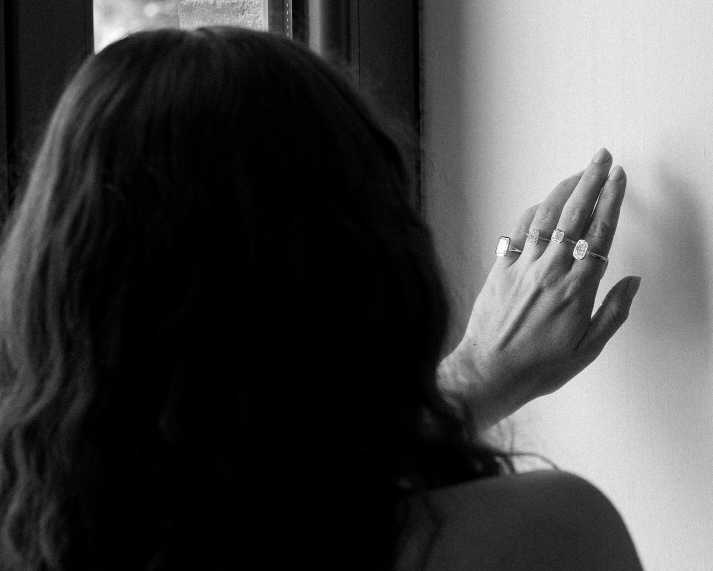 A jewelry designer wearing an assortment of bezel set engagement rings