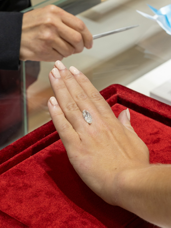 A client inspects a diamond at Market Street Diamons.